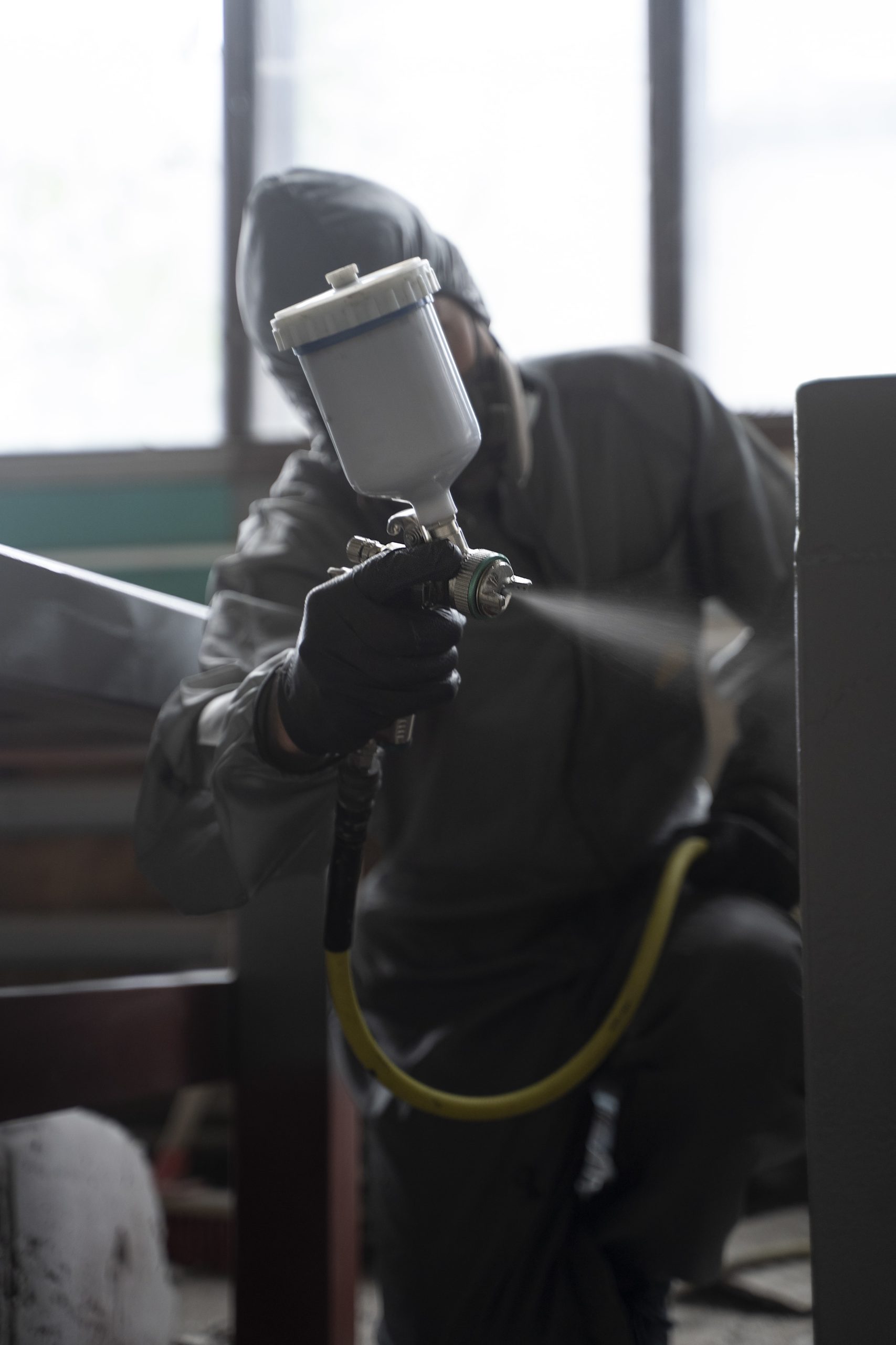 man-spraying-powder-paint-from-gun-front-view-min